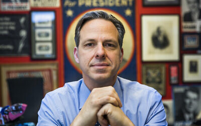 Jake Tapper in his Washington CNN office, which is decorated with posters from losing US presidential campaigns over the decades, in 2016. (Brooks Kraft/Getty Images via JTA)