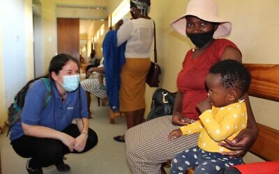 A member of the nonprofit IsraAID (left) speaks to residents of Eswatini at a hospital in the south African country (courtesy)