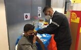 Ahmad Atwan, a Palestinian from a town near Hebron, receives the first dose of a coronavirus vaccine by Magen David Adom during an Israeli campaign to immunize Palestinians who work in Israel (Aaron Boxerman/The Times of Israel)
