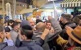 Screen capture from video of a clash between Likud party activits and New Hope party Knesset candidate Ofer Berkovitch as he campaigned in Jerusalem's Mahane Yehudah market, March 15, 2021. (Twitter)