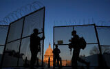 US National Guard soldiers open a gate of the razor wire-topped perimeter fence around the Capitol building in Washington, March 8, 2021. (AP Photo/Carolyn Kaster)
