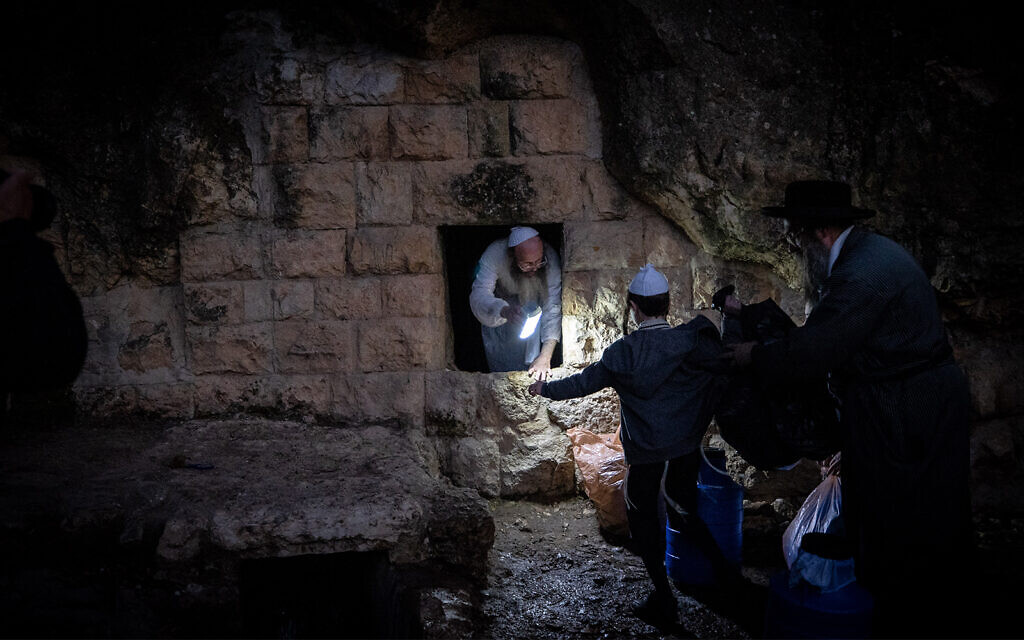 Ultra-Orthodox men collect water from a mountain spring outside Jerusalem on March 25, 2021. The water will be used in the making of matzah. (Yonatan Sindel/Flash90)