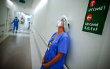 A health worker pauses in the ICU unit for COVID-19 patients at the Hospital das Clinicas in Porto Alegre, Brazil, March 19, 2021. (AP Photo/Jefferson Bernardes)