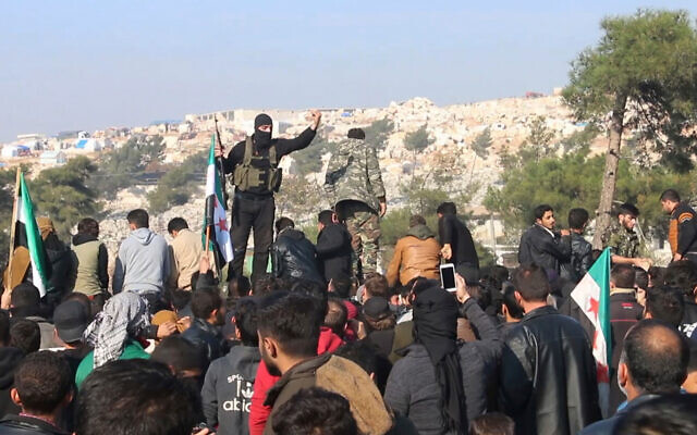 Illustrative: Hayat Tahrir al-Sham jihadists try to disperse people who gathered at the Bab al-Hawa border gate with Turkey to protest bombing by the Syrian regime, Dec. 20, 2019. (AP Photo/APTN)