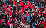 Hapoel Jerusalem soccer fans cheer during a Liga Leumit match between Hapoel Nir Ramat HaSharon and Hapoel Jerusalem at the Teddy Stadium in Jerusalem, March 12, 2021. (Flash90)