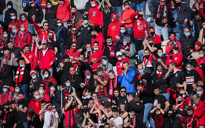 Hapoel Jerusalem soccer fans cheer during a Liga Leumit match between Hapoel Nir Ramat HaSharon and Hapoel Jerusalem at the Teddy Stadium in Jerusalem, March 12, 2021. (Flash90)