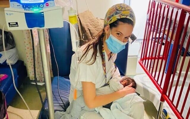 Nurse Yael Cohen with the infant daughter of an East Jerusalem woman who was seriously injured in a car accident, March 10, 2021 (Courtesy Hadassah Medical Center) Nurse Yael Cohen with the infant daughter of an East Jerusalem woman who was seriously injured in a car accident, March 10, 2021 (Courtesy Hadassah Medical Center)