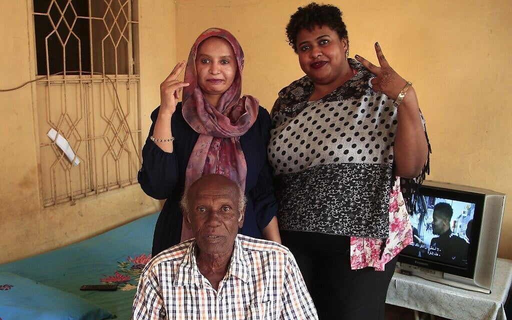 Amin Israil (bottom), the grandson of an Iraqi Jew who settled in Sudan and whose family later converted to Islam, his daughter Salma (L), and Yosar Basha (R), another Sudanese woman descended of Jewish origins, pose for a photo together at Israil's home during an interview with AFP in Wad Madani, the capital of Sudan's east-central al-Jazirah state, on February 11, 2021. - The Jewish community in Sudan was one of the smallest in the Middle East, but it, like those of other Arab states, dwindled in the latter half of the 20th century, as tensions surrounding the 1948 creation of Israel permeated the region. Like elsewhere in the Arab world, Sudanese Jews bore the brunt of growing anti-Israel sentiment amid conflict with the Jewish state. Decades later, their descendants see a recent rapprochement between their country and Israel as an opportunity to connect with their origins. (Photo by Ebrahim HAMID / AFP)