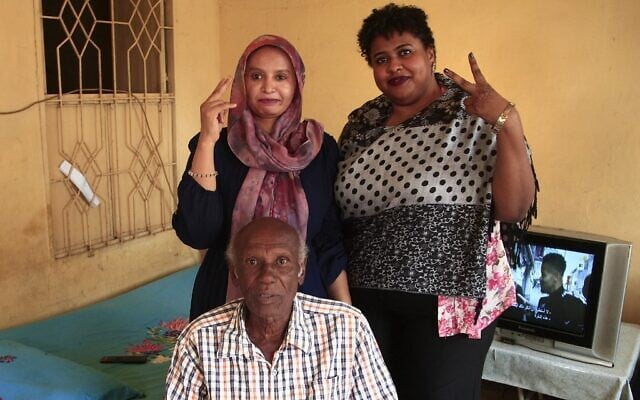 Amin Israil (bottom), the grandson of an Iraqi Jew who settled in Sudan and whose family later converted to Islam, his daughter Salma (L), and Yosar Basha (R), another Sudanese woman descended of Jewish origins, pose for a photo together at Israil's home during an interview with AFP in Wad Madani, the capital of Sudan's east-central al-Jazirah state, on February 11, 2021. - The Jewish community in Sudan was one of the smallest in the Middle East, but it, like those of other Arab states, dwindled in the latter half of the 20th century, as tensions surrounding the 1948 creation of Israel permeated the region. Like elsewhere in the Arab world, Sudanese Jews bore the brunt of growing anti-Israel sentiment amid conflict with the Jewish state. Decades later, their descendants see a recent rapprochement between their country and Israel as an opportunity to connect with their origins. (Photo by Ebrahim HAMID / AFP)