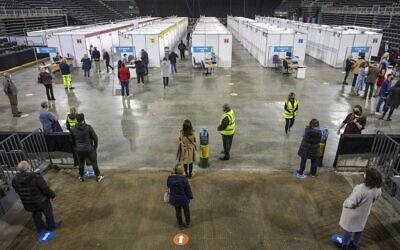 People wait to receive a dose of the AstraZeneca/Oxford vaccine at the SSE Arena which has been converted into a temporary COVID-19 vaccination center, in Belfast, Northern Ireland on March 29, 2021. (Paul Faith / AFP)