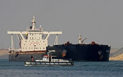 Egyptian coast guards patrol as a ship navigates the Suez Canal on March 30, 2021, a day after a cargo vessel was dislodged from its banks. (Tarek Wajeh/AFP)