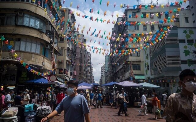 Pedestrians walk on a street in Hong Kong on March 31, 2021. (Anthony WALLACE / AFP) Pedestrians walk on a street in Hong Kong on March 31, 2021. (Anthony WALLACE / AFP)