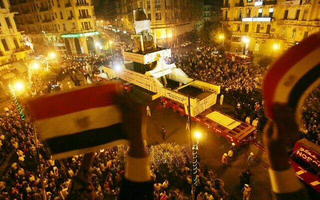 In this file photo taken on August 25, 2006, Egyptians wave their national flag from a balcony as they bid farewell to the Ramses II colossal statue at Talat Harb Square, as it's moved from the polluted capital city Cairo to a spot near the Pyramids in Giza, closer to its original site (Khaled DESOUKI / AFP) In this file photo taken on August 25, 2006, Egyptians wave their national flag from a balcony as they bid farewell to the Ramses II colossal statue at Talat Harb Square, as it's moved from the polluted capital city Cairo to a spot near the Pyramids in Giza, closer to its original site (Khaled DESOUKI / AFP)