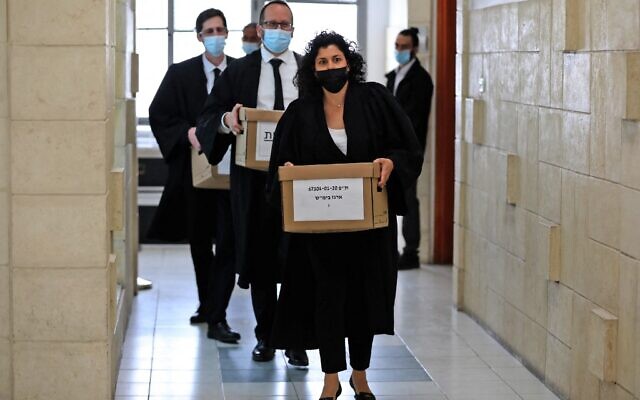 State attorneys carry boxes of files into a hearing in Prime Minister Benjamin Netanyahu's corruption trial at Jerusalem District Court on April 5, 2021. (POOL / AFP) State attorneys carry boxes of files into a hearing in Prime Minister Benjamin Netanyahu's corruption trial at Jerusalem District Court on April 5, 2021. (POOL / AFP)