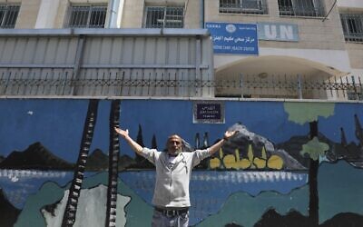 A Palestinian man gestures outside a United Nations health center in the Palestinian refugee camp of Jalazoun near Ramallah on April 8, 2021. (ABBAS MOMANI / AFP)