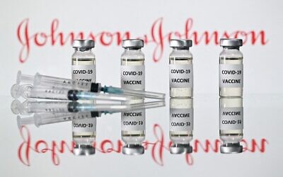 In this file illustration picture taken on November 17, 2020 shows vials with Covid-19 Vaccine stickers attached and syringes with the logo of US pharmaceutical company Johnson & Johnson. - The EU's drug regulator said April 9, 2021 it had launched a review of possible links between the Johnson & Johnson coronavirus vaccine and blood clots after reports of four cases, one of them fatal. (Photo by JUSTIN TALLIS / AFP)