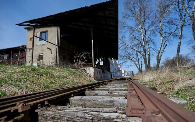 Old train tracks leading past a former canteen building of SS guards at the former Nazi death camp Auschwitz-Birkenau, in Oswiecim, Poland, April 9, 2021 (BARTOSZ SIEDLIK / AFP)