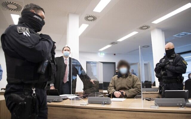 Defendant Abdullah A (C), accused of stabbing a German tourist to death in Dresden, sits next to judicial officials and his lawyer Peter Hollstein (2ndL) at the start of his trial at the Higher Regional Court in Dresden, eastern Germany, on April 12, 2021 (Sebastian Kahnert / POOL / AFP) Defendant Abdullah A (C), accused of stabbing a German tourist to death in Dresden, sits next to judicial officials and his lawyer Peter Hollstein (2ndL) at the start of his trial at the Higher Regional Court in Dresden, eastern Germany, on April 12, 2021 (Sebastian Kahnert / POOL / AFP)