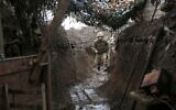 A Ukrainian serviceman walks along a trench at a position on the frontline with Russia-backed separatists near Gorlivka, Donetsk region, on April 14, 2021. (STR / AFP)