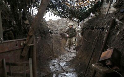 A Ukrainian serviceman walks along a trench at a position on the frontline with Russia-backed separatists near Gorlivka, Donetsk region, on April 14, 2021. (STR / AFP)