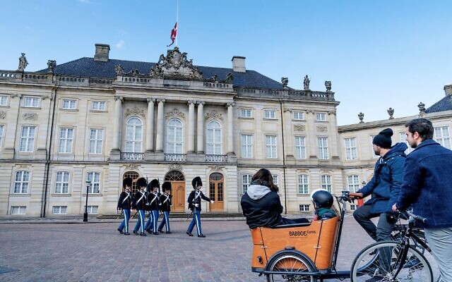 Royal guards march as the Danish national flag flies at half mast at Amalienborg Palace in Copenhagen on April 17, 2021, on the occasion of the funeral of Britain's Prince Philip, Duke of Edinburgh. - Philip, who was married to Queen Elizabeth II for 73 years, died on April 9 aged 99 just weeks after a month-long stay in hospital for treatment to a heart condition and an infection. (Photo by Claus Bech / Ritzau Scanpix / AFP) / Denmark OUT