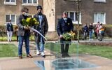 Participants lay a wreath and flowers in front of a monument dedicated to the underground archives of the Jewish ghetto, during its unveiling ceremony at the site where the Ringelblum Archive was hidden during Nazi occupation during the Second World War, in Warsaw, on April 19, 2021. (Wojtek RADWANSKI/ AFP)