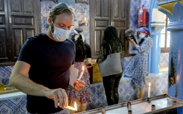 A Tunisian Jewish pilgrim lights a candle on the first day of the annual pilgrimage to the Ghriba Synagogue, the oldest Jewish monument built in Africa, on April 26, 2021, in the Mediterranean Tunisian resort island of Djerba. (Fathi Nasri/AFP)