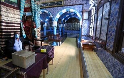 File - A Tunisian Jewish caretaker sits on the entrance of the Ghriba Synagogue, the oldest Jewish monument in Africa, on the first day of the annual pilgrimage in the Mediterranean Tunisian resort island of Djerba on April 26, 2021. (Fathi Nasri/AFP)