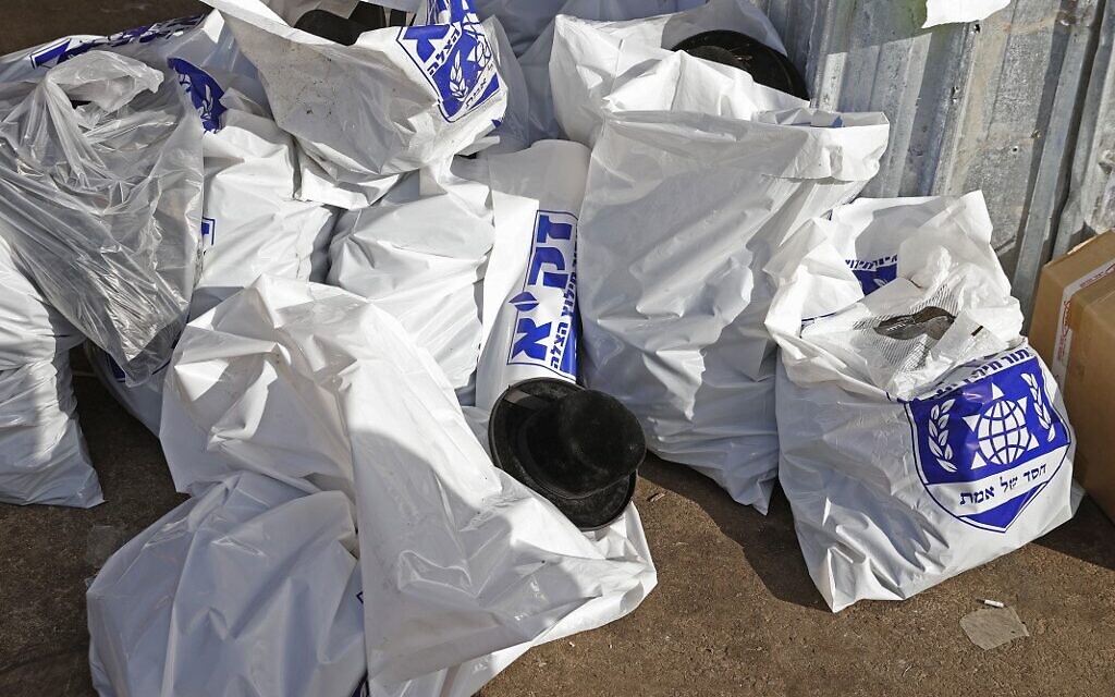 A photo taken on April 30, 2021 following a deadly crush in Meron shows plastic bags with shoes and hats belonging to people who were attending a religious gathering overnight in the northern Israeli town near the reputed tomb of Rabbi Shimon Bar Yochai, a second-century Talmudic sage, where mainly ultra-Orthodox Jews flock to mark the Lag BaOmer holiday. (JACK GUEZ / AFP)