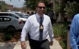Joel Greenberg, bearing his tax collector badge and a sidearm, appears in a TV news report about his legal troubles in Seminole County, Florida, Jan. 25, 2021. (YouTube via JTA)