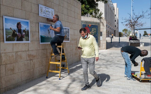 Hanging photographic portraits of Holocaust survivors that are part of The Lonka Project being exhibited in Safra Square in Jerusalem, opening April 8, 2021, Yom HaShaoh, Israeli Heroes and Martyrs remembrance day, and will run for four months, until at least August 2021 (Courtesy The Lonka Project) Hanging photographic portraits of Holocaust survivors that are part of The Lonka Project being exhibited in Safra Square in Jerusalem, opening April 8, 2021, Yom HaShaoh, Israeli Heroes and Martyrs remembrance day, and will run for four months, until at least August 2021 (Courtesy The Lonka Project)