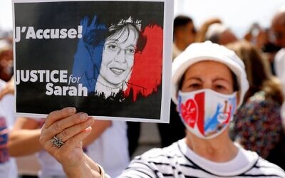 A woman holds up a sign during the day of rallies around the world protesting the French judicial system's handling of the Sarah Halimi case, April 25, 2021. (Jack Guez/AFP/Getty Images/ via JTA)