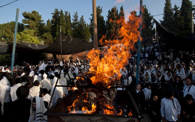 Ultra-Orthodox Jews covered with prayer shawls gather next to fire as they take part in prayers next to the grave of Rabbi Shimon bar Yochai during Lag B'Omer celebrations at Mt. Meron in northern Israel, early Thursday, May 10, 2012.  (AP Photo/Ariel Schalit)