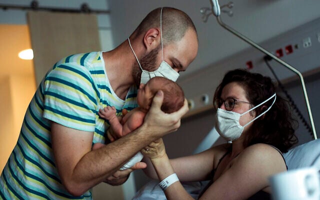 A father, wearing a face mask to protect against the spread of coronavirus, brings his newborn daughter her mother for breastfeeding in Liege, Belgium, June 26, 2020. (AP Photo/Francisco Seco) A father, wearing a face mask to protect against the spread of coronavirus, brings his newborn daughter her mother for breastfeeding in Liege, Belgium, June 26, 2020. (AP Photo/Francisco Seco)