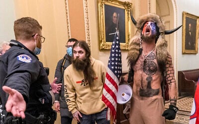 In this January 6, 2021 file photo, supporters of then-US president Donald Trump, including Jacob Chansley, right with fur hat, are confronted by US Capitol Police officers outside the Senate Chamber inside the Capitol in Washington. (AP Photo/Manuel Balce Ceneta, File)