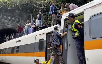 In this image made from a video released by hsnews.com.tw, passengers are helped to climb out of a derailed train in Hualien County in eastern Taiwan, April 2, 2021. (hsnews.com.tw via AP)