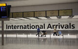 Illustrative: Arriving passengers walk past a sign in the arrivals area at Heathrow Airport in London, Jan. 26, 2021. (Matt Dunham/AP)