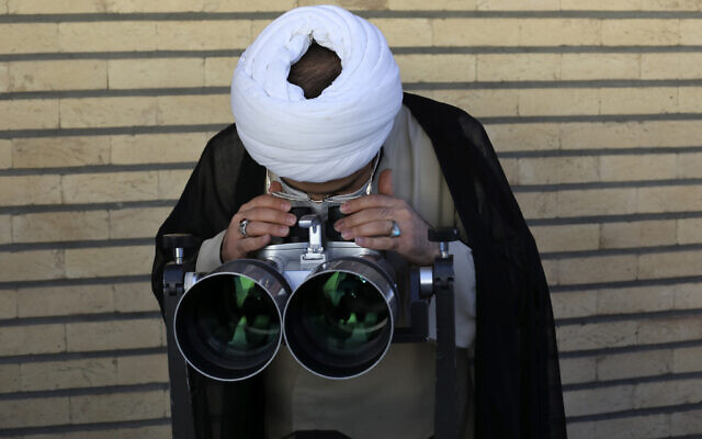 A clergyman searches the sky with a telescope for the new moon that signals the start of the Islamic holy fasting month of Ramadan, at the Imam Ali observatory about 28 miles (45 kilometers) outside the holy city of Qom, south of the capital Tehran, Iran, April 13, 2021. (AP Photo/Vahid Salemi) A clergyman searches the sky with a telescope for the new moon that signals the start of the Islamic holy fasting month of Ramadan, at the Imam Ali observatory about 28 miles (45 kilometers) outside the holy city of Qom, south of the capital Tehran, Iran, April 13, 2021. (AP Photo/Vahid Salemi)