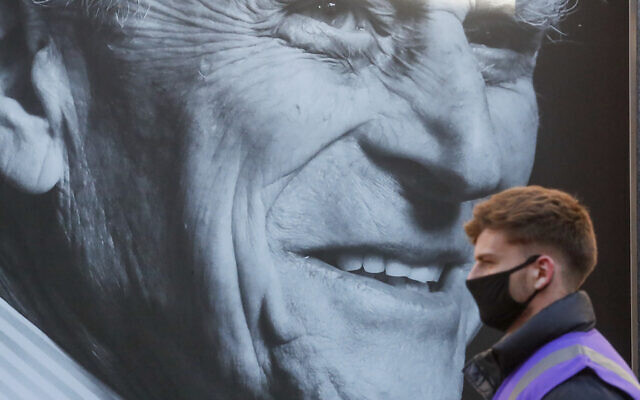 A man walks past a portrait of Britain's Prince Philip ahead of his funeral in Windsor, England Saturday April 17, 2021.  (AP/Frank Augstein)