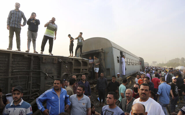 People gather at the site where a passenger train derailed, injuring at least 100 people, in Banha, Qalyubia province, Egypt, on April 18, 2021. (AP Photo/Fadel Dawood) People gather at the site where a passenger train derailed, injuring at least 100 people, in Banha, Qalyubia province, Egypt, on April 18, 2021. (AP Photo/Fadel Dawood)