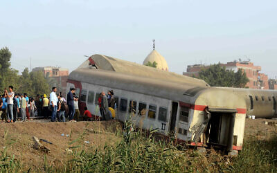 People gather at the site where a passenger train derailed killing at least 11 people and injuring at least 98 others, near Banha, Qalyubia province, Egypt. (AP Photo/Tarek Wagih, File)