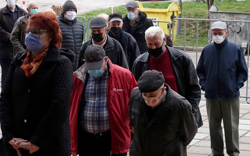 People wait for a COVID-19 vaccine, outside a sports hall in the capital Sarajevo, Bosnia, Wednesday, April 21, 2021. (AP Photo/Eldar Emric)