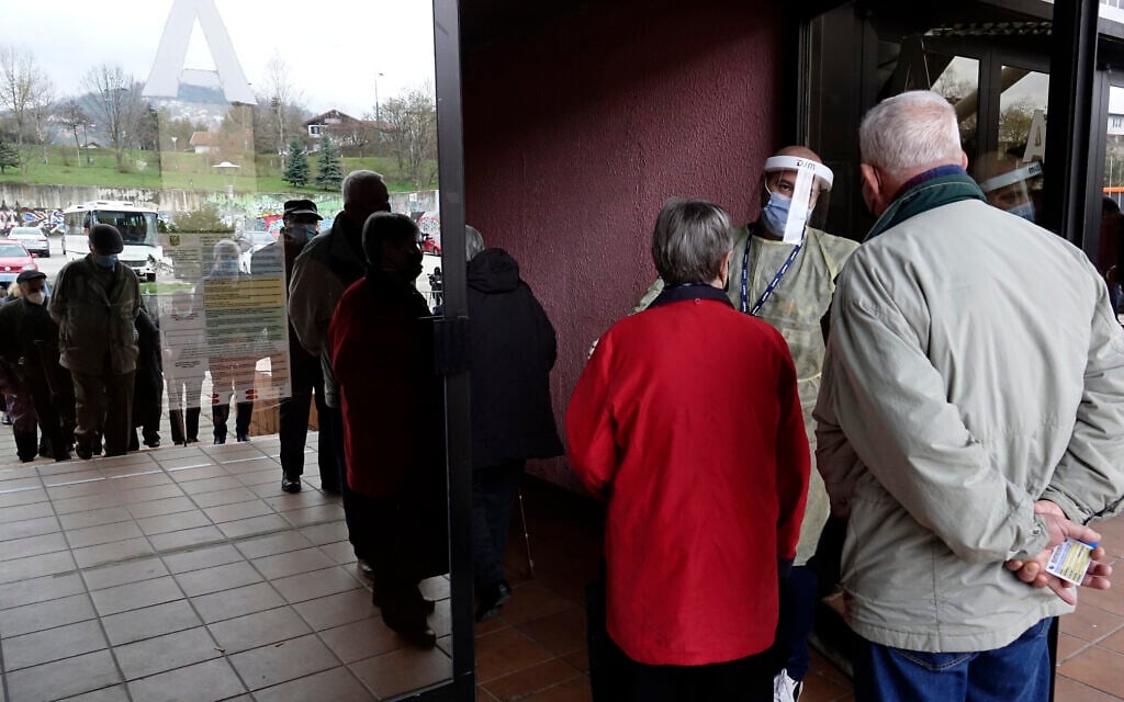 People wait for a COVID-19 vaccine at a sports hall in the capital Sarajevo, Bosnia, Wednesday, April 21, 2021. (AP Photo/Eldar Emric)