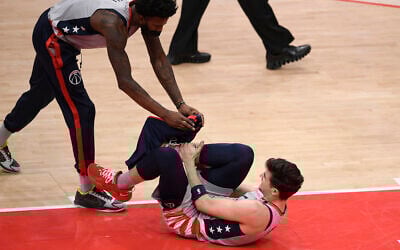 Washington Wizards forward Deni Avdija, bottom, reacts after he was injured during the first half of an NBA basketball game against the Golden State Warriors, April 21, 2021, in Washington. Also seen is Wizards center Jordan Bell (7). (AP Photo/Nick Wass)