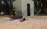 Israeli boys examine the site where a rocket fired from the Gaza Strip landed in Israel, April 24, 2021 (AP Photo/Tsafrir Abayov)