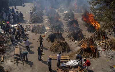 Multiple funeral pyres of victims of COVID-19 burn at a ground that has been converted into a crematorium for mass cremation in New Delhi, India, April 24, 2021. (Altaf Qadri/AP)