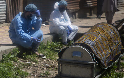 Relatives mourn near a coffin containing the body of a person who died of COVID-19, in Srinagar, Indian controlled Kashmir, April 25, 2021. (Mukhtar Khan/ AP) Relatives mourn near a coffin containing the body of a person who died of COVID-19, in Srinagar, Indian controlled Kashmir, April 25, 2021. (Mukhtar Khan/ AP)