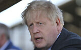 Britain's Prime Minister Boris Johnson visits a farm as he campaigns on behalf of the Conservative Party for local elections, at Moreton farm near Wrexham, north Wales, Monday, April 26, 2021. (Paul Ellis/Pool Photo via AP)