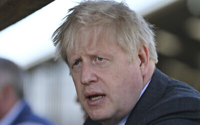 Britain's Prime Minister Boris Johnson visits a farm as he campaigns on behalf of the Conservative Party for local elections, at Moreton farm near Wrexham, north Wales, Monday, April 26, 2021. (Paul Ellis/Pool Photo via AP)