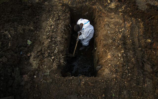 A man in protective suit digs earth to bury the body of a person who died of COVID-19 in Gauhati, India, April 25, 2021. (AP Photo/Anupam Nath, File) A man in protective suit digs earth to bury the body of a person who died of COVID-19 in Gauhati, India, April 25, 2021. (AP Photo/Anupam Nath, File)